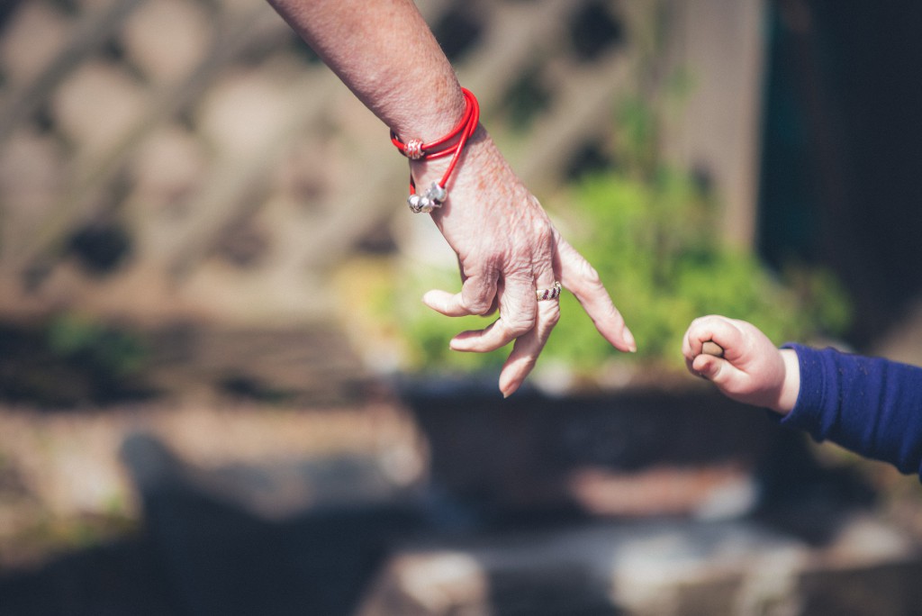 Grandmaother And Childs Hands About To Touch